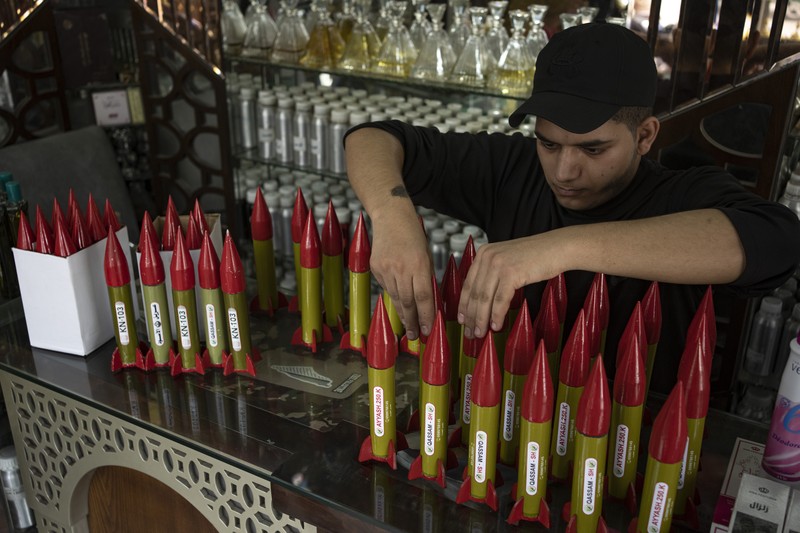 Belal Abu Saraya poses with a perfume container representing rockets used against Israel in a perfume store against Israel in past conflicts at his shop in Gaza City on Thursday, Oct. 5, 2023. AP Photo/Fatima Shbair)