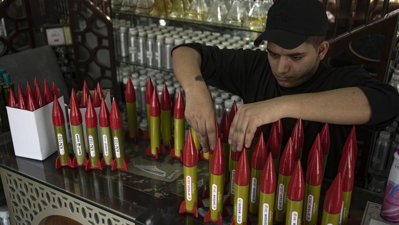Belal Abu Saraya poses with a perfume container representing rockets used against Israel in a perfume store against Israel in past conflicts at his shop in Gaza City on Thursday, Oct. 5, 2023. AP Photo/Fatima Shbair)