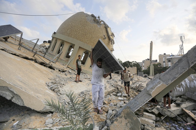 Israel Palestinians Daily Photo Gallery Rockets are fired from the Gaza Strip toward Israel over destroyed buildings following Israeli airstrikes on Gaza City, central Gaza Strip, Thursday, Oct. 19, 2023. (AP Photo/Mohammed Dahman)