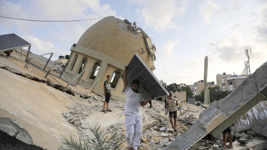 Rockets are fired from the Gaza Strip toward Israel over destroyed buildings following Israeli airstrikes on Gaza City, central Gaza Strip, Thursday, Oct. 19, 2023. (AP Photo/Mohammed Dahman)