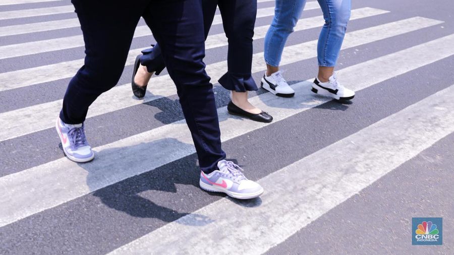 Warga berjalan di sekitar Halte Tosari saat Hari Kulminasi Utama yang jatuh pada pukul 11.40 WIB di Jakarta, Senin (9/10/2023). Hari Kulminasi Utama atau fenomena Hari Tanpa Bayang merupakan posisi dimana matahari berada di posisi tertinggi. (CNBC Indonesia/Faisal Rahman)