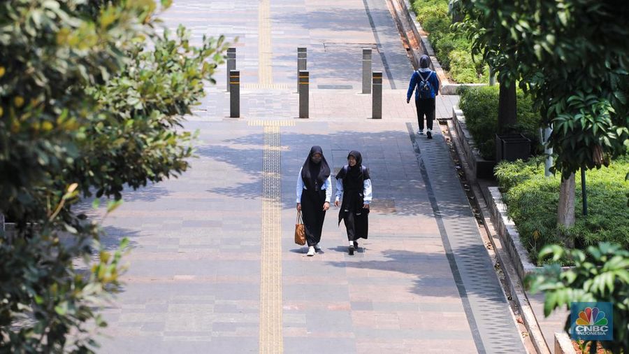 Warga berjalan di sekitar Halte Tosari saat Hari Kulminasi Utama yang jatuh pada pukul 11.40 WIB di Jakarta, Senin (9/10/2023). Hari Kulminasi Utama atau fenomena Hari Tanpa Bayang merupakan posisi dimana matahari berada di posisi tertinggi. (CNBC Indonesia/Faisal Rahman)