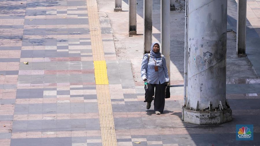 Warga berjalan di sekitar Halte Tosari saat Hari Kulminasi Utama yang jatuh pada pukul 11.40 WIB di Jakarta, Senin (9/10/2023). Hari Kulminasi Utama atau fenomena Hari Tanpa Bayang merupakan posisi dimana matahari berada di posisi tertinggi. (CNBC Indonesia/Faisal Rahman)