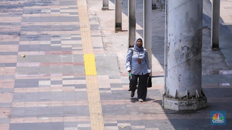 Warga berjalan di sekitar Halte Tosari saat Hari Kulminasi Utama yang jatuh pada pukul 11.40 WIB di Jakarta, Senin (9/10/2023). Hari Kulminasi Utama atau fenomena Hari Tanpa Bayang merupakan posisi dimana matahari berada di posisi tertinggi. (CNBC Indonesia/Faisal Rahman)