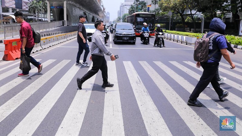 Warga berjalan di sekitar Halte Tosari saat Hari Kulminasi Utama yang jatuh pada pukul 11.40 WIB di Jakarta, Senin (9/10/2023). Hari Kulminasi Utama atau fenomena Hari Tanpa Bayang merupakan posisi dimana matahari berada di posisi tertinggi. (CNBC Indonesia/Faisal Rahman)