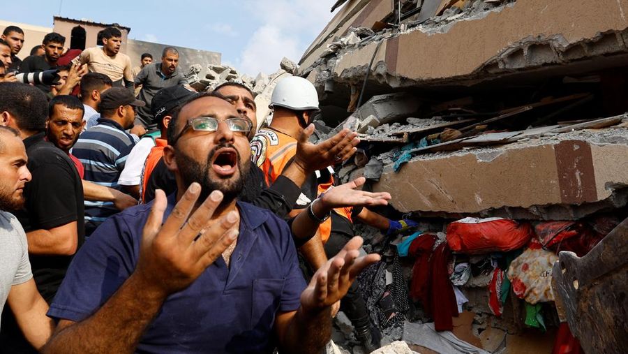 Warga Palestina mencari keluarga mereka yang menjadi korban di antara puing-puing rumah yang hancur akibat serangan Israel di Khan Younis, di Jalur Gaza selatan, 8 Oktober 2023. (REUTERS/Ibraheem Abu Mustafa)
