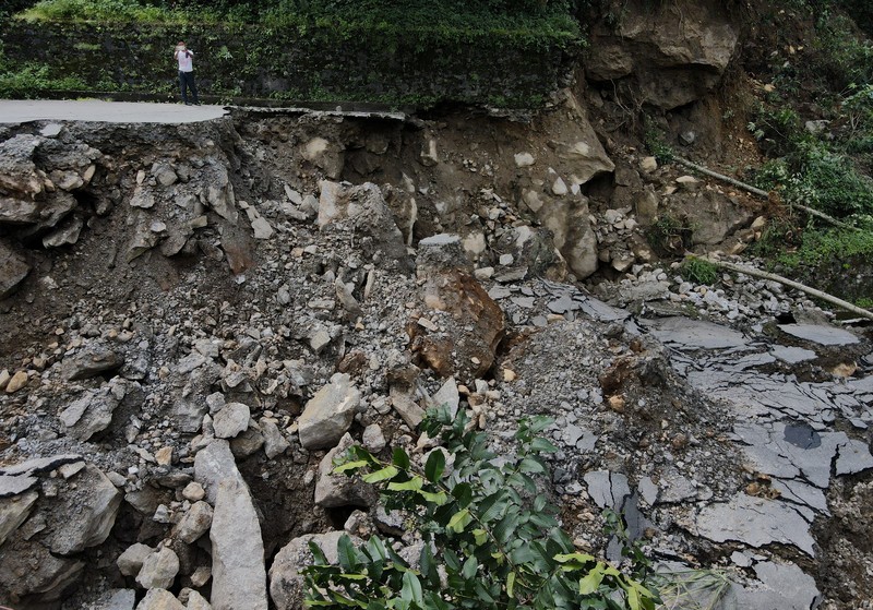Monks walk along a road with cracks caused by flash floods in Naga-Namgor village, Sikkim, India, October 10, 2023. REUTERS/Francis Mascarenhas