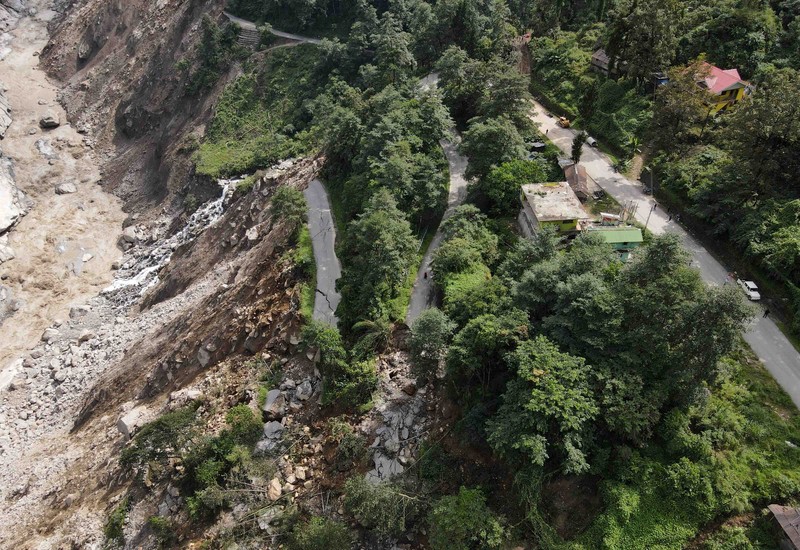INDIA-FLOODS/ Monks walk along a road with cracks caused by flash floods in Naga-Namgor village, Sikkim, India, October 10, 2023. REUTERS/Francis Mascarenhas