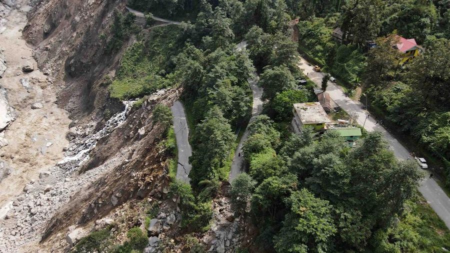 Monks walk along a road with cracks caused by flash floods in Naga-Namgor village, Sikkim, India, October 10, 2023. REUTERS/Francis Mascarenhas