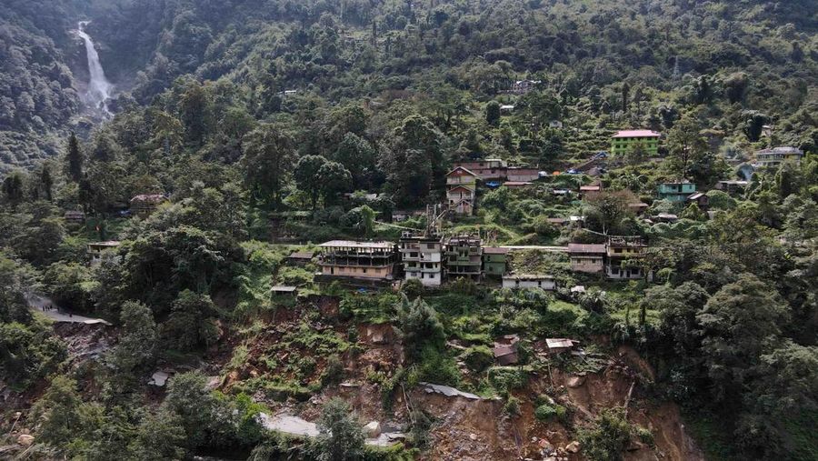Monks walk along a road with cracks caused by flash floods in Naga-Namgor village, Sikkim, India, October 10, 2023. REUTERS/Francis Mascarenhas