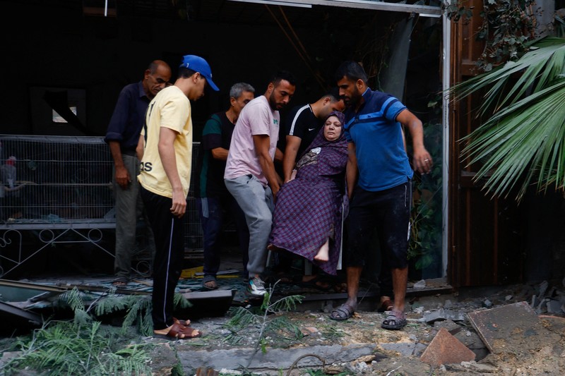 ISRAEL-PALESTINIANS/ A medic runs as he carries an injured Palestinian child to ambulance in this screengrab taken from a video, in Gaza, October 9, 2023. REUTERS/Stringer NO RESALES. NO ARCHIVES TPX IMAGES OF THE DAY