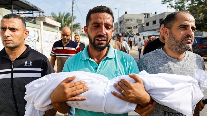 A medic runs as he carries an injured Palestinian child to ambulance in this screengrab taken from a video, in Gaza, October 9, 2023. REUTERS/Stringer NO RESALES. NO ARCHIVES     TPX IMAGES OF THE DAY