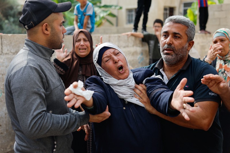 ISRAEL-PALESTINIANS/ A medic runs as he carries an injured Palestinian child to ambulance in this screengrab taken from a video, in Gaza, October 9, 2023. REUTERS/Stringer NO RESALES. NO ARCHIVES TPX IMAGES OF THE DAY