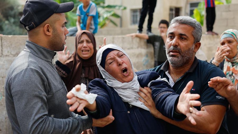 A medic runs as he carries an injured Palestinian child to ambulance in this screengrab taken from a video, in Gaza, October 9, 2023. REUTERS/Stringer NO RESALES. NO ARCHIVES     TPX IMAGES OF THE DAY