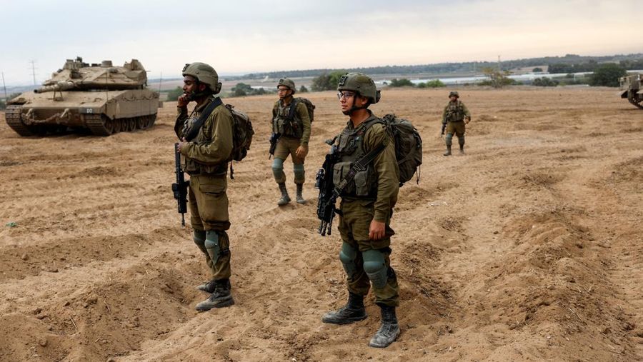 Tentara Israel mengawasi area di mana tank dan kendaraan milisi Israel berkumpul di sisi perbatasan Gaza. (REUTERS/Amir Cohen)