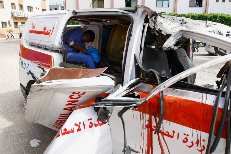 Palestinian medics inspect a damaged Ambulance hit by an Israeli air strike inside Nasser Hospital in Khan Younis, southern Gaza Strip, Saturday, Oct. 7, 2023. The militant Hamas rulers of the Gaza Strip carried out an unprecedented, multi-front attack on Israel at daybreak Saturday, firing thousands of rockets as dozens of Hamas fighters infiltrated the heavily fortified border in several locations by air, land, and sea and catching the country off-guard on a major holiday. (AP Photo/Hassan Eslaiah)