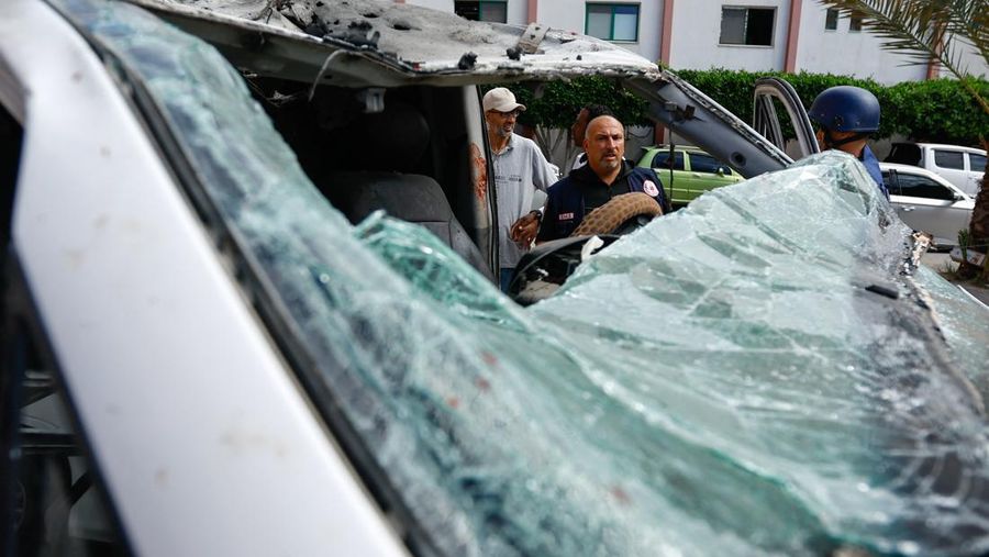Palestinian medics inspect a damaged Ambulance hit by an Israeli air strike inside Nasser Hospital in Khan Younis, southern Gaza Strip, Saturday, Oct. 7, 2023. The militant Hamas rulers of the Gaza Strip carried out an unprecedented, multi-front attack on Israel at daybreak Saturday, firing thousands of rockets as dozens of Hamas fighters infiltrated the heavily fortified border in several locations by air, land, and sea and catching the country off-guard on a major holiday. (AP Photo/Hassan Eslaiah)