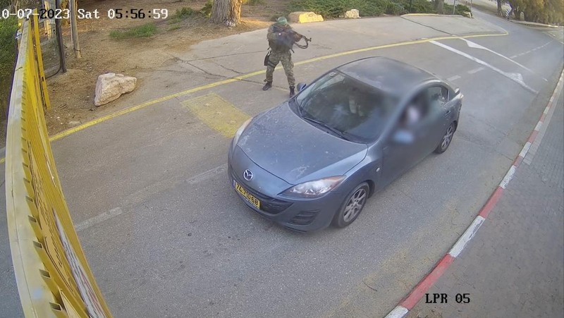 CCTV footage shows a Hamas Islamist militant firing upon a car during an ambush while the occupants were waiting to enter the Be'eri kibbutz through a gate, in southern Israel, October 7, 2023 in this still image from video. South First Responders via Telegram via REUTERS   THIS IMAGE HAS BEEN SUPPLIED BY A THIRD PARTY. MANDATORY CREDIT. NO RESALES. NO ARCHIVES. IMAGE BLURRED AT SOURCE