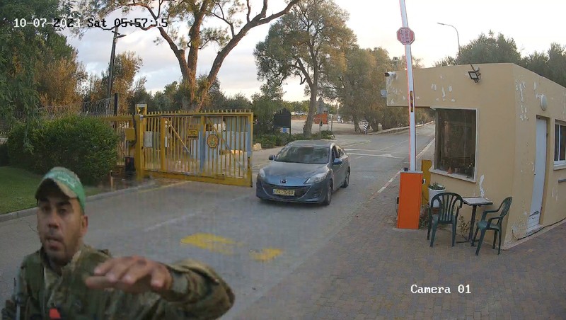 ISRAEL-PALESTINIANS/KIBBUTZ CCTV footage shows a Hamas Islamist militant firing upon a car during an ambush while the occupants were waiting to enter the Be'eri kibbutz through a gate, in southern Israel, October 7, 2023 in this still image from video. South First Responders via Telegram via REUTERS THIS IMAGE HAS BEEN SUPPLIED BY A THIRD PARTY. MANDATORY CREDIT. NO RESALES. NO ARCHIVES. IMAGE BLURRED AT SOURCE