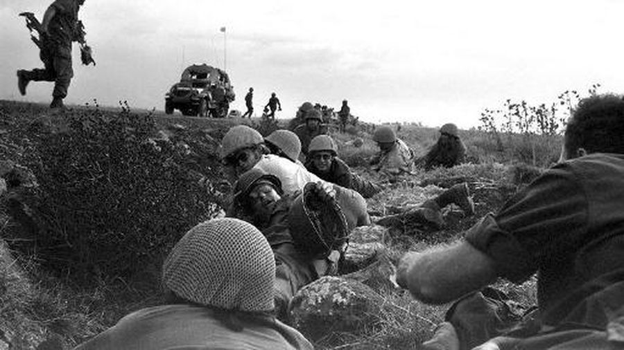 Israeli soldiers and journalists take cover from Syrian planes strafing the road on the Golan Heights during the 1973 ArabIsraeli War on October 08, 1973. On October 6, 1973, on the Jewish holiday of Yom Kippur, an Arab military coalition led by Egypt and Syria launched a simultaneous surprise attack in the Sinai Peninsula and the Golan Heights, territories occupied by Israel since the 1967 ArabIsraeli War. This war provoked the oil shock of 1973 and led to the opening of peace negotiations between Israel and Egypt, concluded by the Camp David agreement in 1978. (Photo by ZE'EV SPECTOR / GPO / AFP)