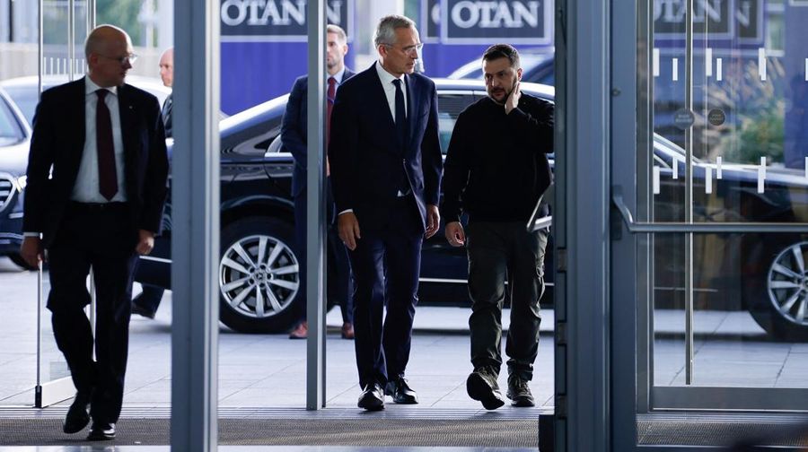 Presiden Ukraina Volodymyr Zelenskiy dan Sekretaris Jenderal NATO Jens Stoltenberg berjalan pada hari pertemuan Menteri Pertahanan NATO di markas besar Aliansi di Brussels, Belgia, Rabu (11/10/2023). (REUTERS/Johanna Geron)