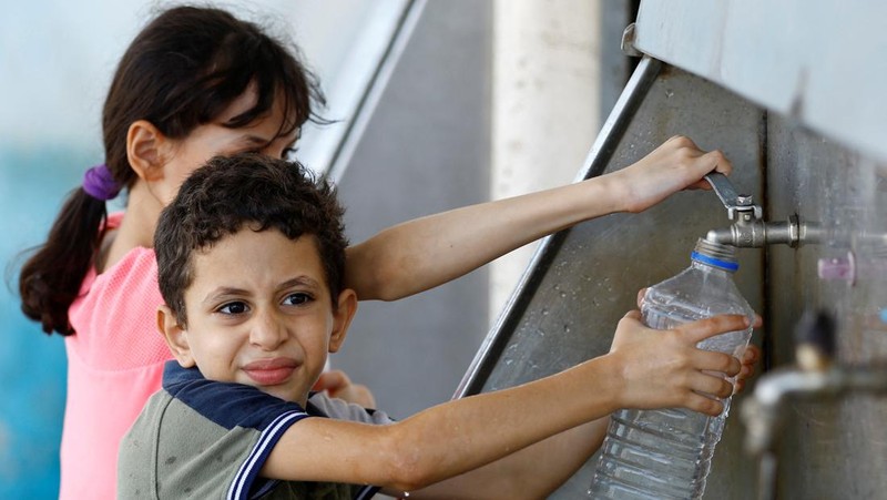 Sejumlah anak antre untuk mendapatkan air bersih di jalur Gaza. (REUTERS/Ibraheem Abu Mustafa)