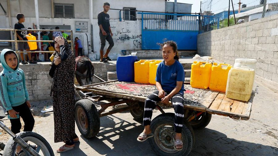 Sejumlah anak antre untuk mendapatkan air bersih di jalur Gaza. (REUTERS/Ibraheem Abu Mustafa)