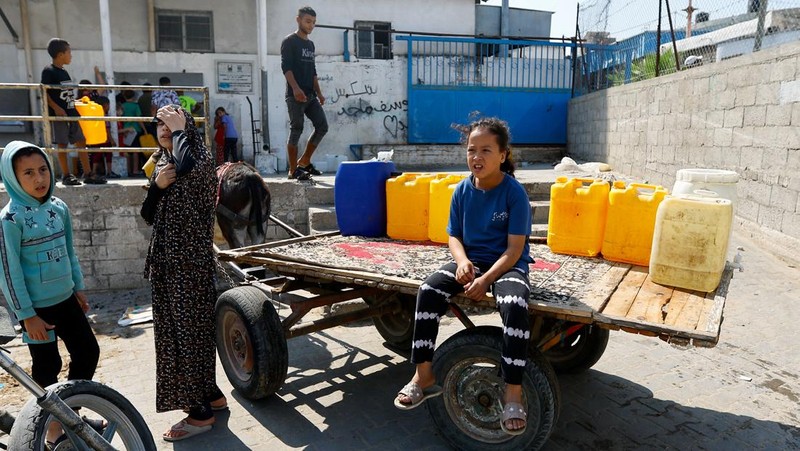 Sejumlah anak antre untuk mendapatkan air bersih di jalur Gaza. (REUTERS/Ibraheem Abu Mustafa)