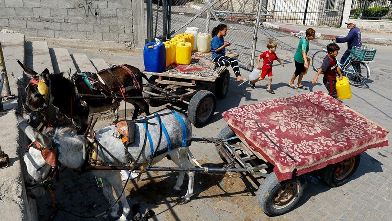 Sejumlah anak antre untuk mendapatkan air bersih di jalur Gaza. (REUTERS/Ibraheem Abu Mustafa)