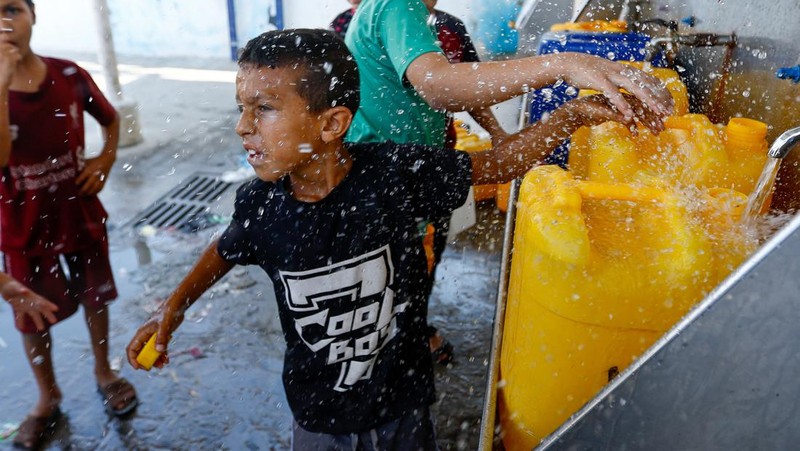 Sejumlah anak antre untuk mendapatkan air bersih di jalur Gaza. (REUTERS/Ibraheem Abu Mustafa)