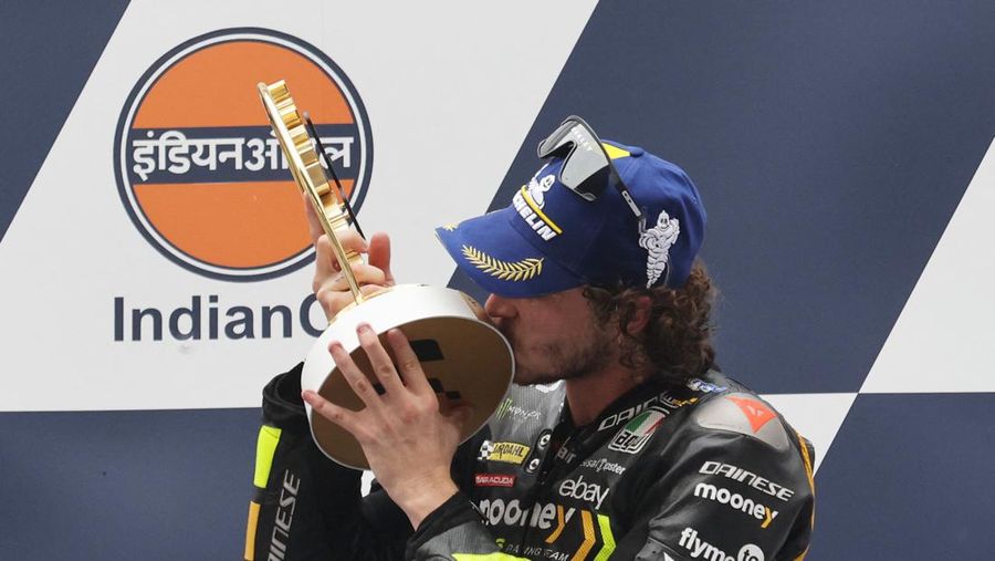 Marco Bezzecchi dari Tim Balap Mooney VR46 merayakan dengan trofi di podium setelah memenangkan. (REUTERS/ANUSHREE FADNAVIS)