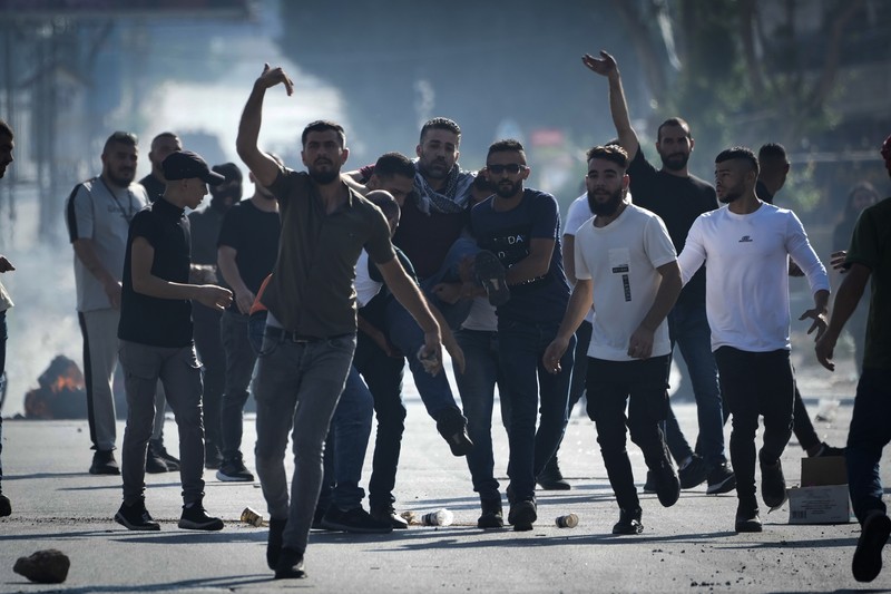 Para pengunjuk rasa membakar ban ketika warga Palestina mengambil bagian dalam protes menyusul serangan Israel di Gaza. (REUTERS/Mussa Qawasma) Para pengunjuk rasa membakar ban ketika warga Palestina mengambil bagian dalam protes menyusul serangan Israel di Gaza. (REUTERS/Mussa Qawasma)