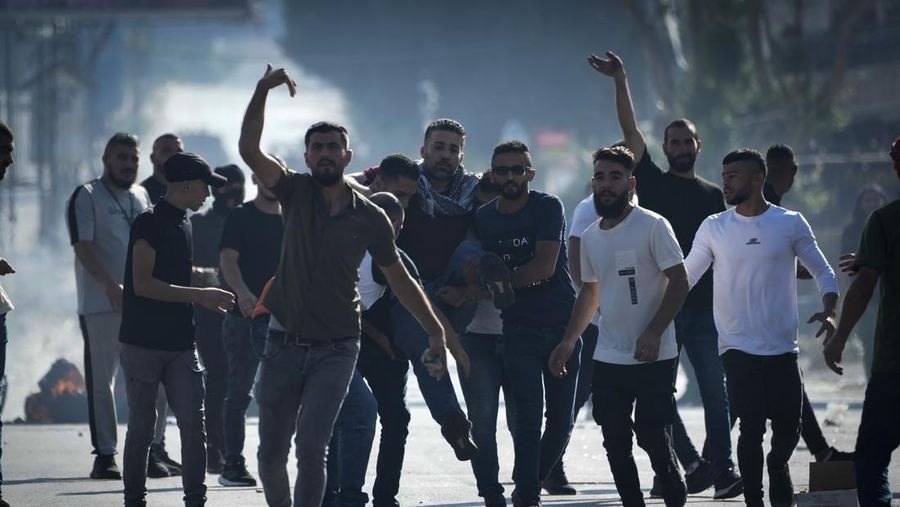 Para pengunjuk rasa membakar ban ketika warga Palestina mengambil bagian dalam protes menyusul serangan Israel di Gaza. (REUTERS/Mussa Qawasma)