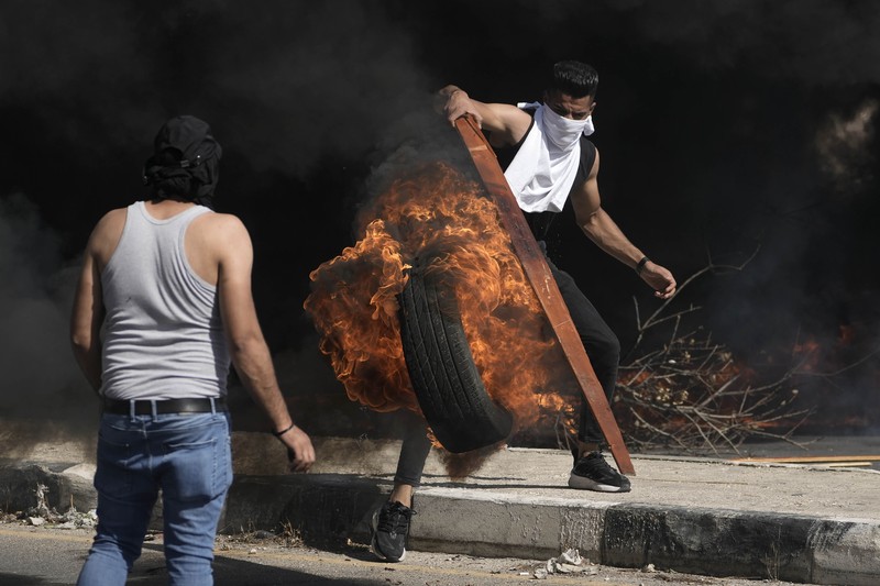 Para pengunjuk rasa membakar ban ketika warga Palestina mengambil bagian dalam protes menyusul serangan Israel di Gaza. (REUTERS/Mussa Qawasma) Para pengunjuk rasa membakar ban ketika warga Palestina mengambil bagian dalam protes menyusul serangan Israel di Gaza. (REUTERS/Mussa Qawasma)