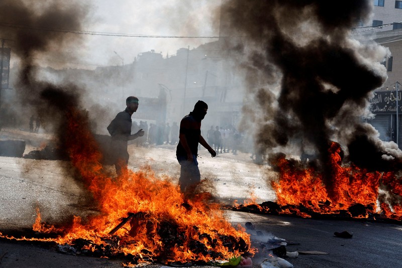 Para pengunjuk rasa membakar ban ketika warga Palestina mengambil bagian dalam protes menyusul serangan Israel di Gaza. (REUTERS/Mussa Qawasma) Para pengunjuk rasa membakar ban ketika warga Palestina mengambil bagian dalam protes menyusul serangan Israel di Gaza. (REUTERS/Mussa Qawasma)