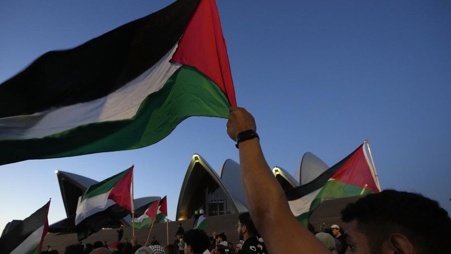 Pendukung Palestina mengibarkan bendera saat mereka berbaris menuju Sydney Opera House di Sydney, Senin, 9 Oktober 2023. (AP Photo/Rick Rycroft)
