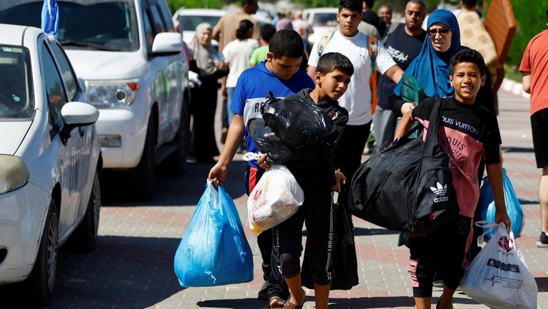 Warga Gaza meninggalkan rumah mereka di tengah konflik Israel-Palestina di Khan Younis di selatan Jalur Gaza (13/10/2023) waktu setempat. (REUTERS/Ahmed Zakot)