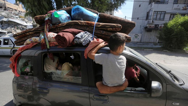 Warga Gaza meninggalkan rumah mereka di tengah konflik Israel-Palestina di Khan Younis di selatan Jalur Gaza (13/10/2023) waktu setempat. (REUTERS/Ahmed Zakot)