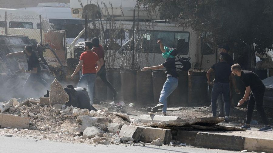 Para pengunjuk rasa membakar ban ketika warga Palestina mengambil bagian dalam protes menyusul serangan Israel di Gaza. (REUTERS/Mussa Qawasma)