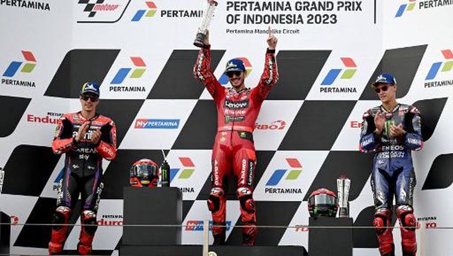 Posisi pertama Ducati Lenovo Teams pebalap Italia Francesco Bagnaia (tengah), peringkat kedua pembalap Aprilia asal Spanyol Maverick Vinales (kiri), dan peringkat ketiga pebalap Monster Energy Yamaha MotoGP asal Prancis Fabio Quartararo merayakan seremoni podium usai berlaga di Grand Indonesia. Prix MotoGP di Sirkuit Internasional Mandalika di Kuta Mandalika, Lombok Tengah pada 15 Oktober 2023. ( SONNY TUMBELAKA / AFP)