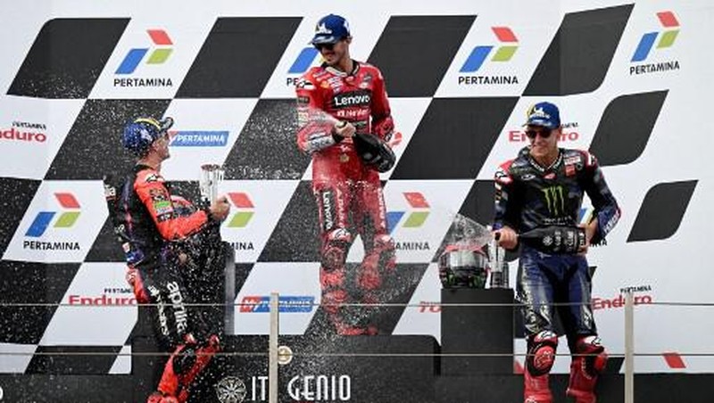 Posisi pertama Ducati Lenovo Teams pebalap Italia Francesco Bagnaia (tengah), peringkat kedua pembalap Aprilia asal Spanyol Maverick Vinales (kiri), dan peringkat ketiga pebalap Monster Energy Yamaha MotoGP asal Prancis Fabio Quartararo merayakan seremoni podium usai berlaga di Grand Indonesia. Prix MotoGP di Sirkuit Internasional Mandalika di Kuta Mandalika, Lombok Tengah pada 15 Oktober 2023. ( SONNY TUMBELAKA / AFP)