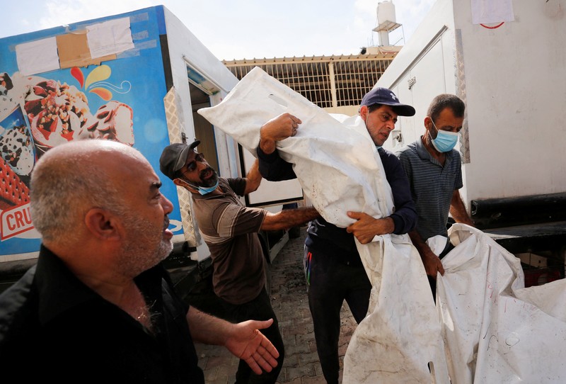 Orang-orang membawa jenazah seorang warga Palestina, yang tewas dalam serangan Israel, dari truk es krim tempatnya disimpan, saat kamar mayat rumah sakit penuh sesak, di tengah konflik Israel-Palestina yang sedang berlangsung, di Jalur Gaza tengah, 15 Oktober 2023. Orang-orang membawa jenazah seorang warga Palestina, yang tewas dalam serangan Israel, dari truk es krim tempatnya disimpan, saat kamar mayat rumah sakit penuh sesak, di tengah konflik Israel-Palestina yang sedang berlangsung, di Jalur Gaza tengah, 15 Oktober 2023. (REUTERS/Stringer)