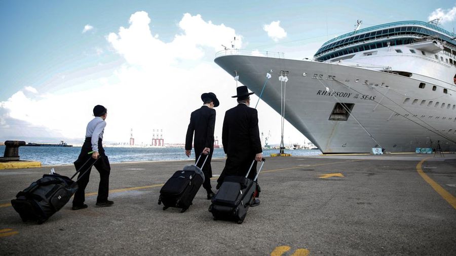 Orang-orang Yahudi ultra-Ortodoks membawa barang-barang mereka sebelum menaiki kapal untuk warga negara AS dan anggota keluarga dekat mereka ketika mereka meninggalkan Israel menuju Siprus, di tengah konflik yang sedang berlangsung antara Israel dan kelompok Islam Palestina Hamas, di Haifa, Israel, 16 Oktober 2023 . (REUTERS/Shir Torem)