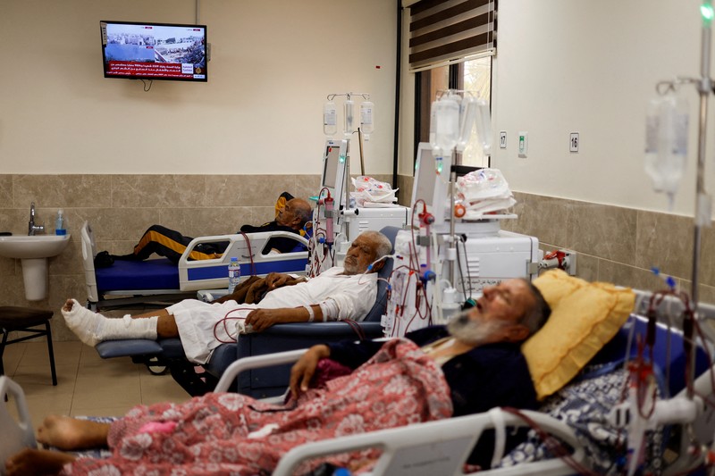 Orang-orang membawa jenazah seorang warga Palestina, yang tewas dalam serangan Israel, dari truk es krim tempatnya disimpan, saat kamar mayat rumah sakit penuh sesak, di tengah konflik Israel-Palestina yang sedang berlangsung, di Jalur Gaza tengah, 15 Oktober 2023. (REUTERS/Stringer)