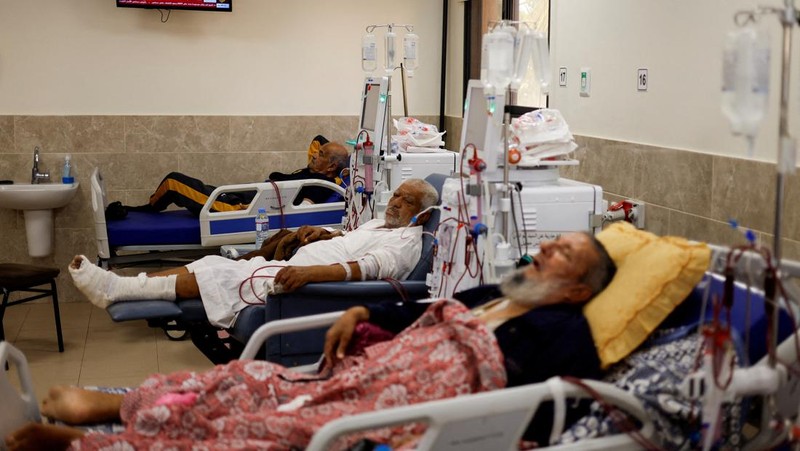 Orang-orang membawa jenazah seorang warga Palestina, yang tewas dalam serangan Israel, dari truk es krim tempatnya disimpan, saat kamar mayat rumah sakit penuh sesak, di tengah konflik Israel-Palestina yang sedang berlangsung, di Jalur Gaza tengah, 15 Oktober 2023. (REUTERS/Stringer)