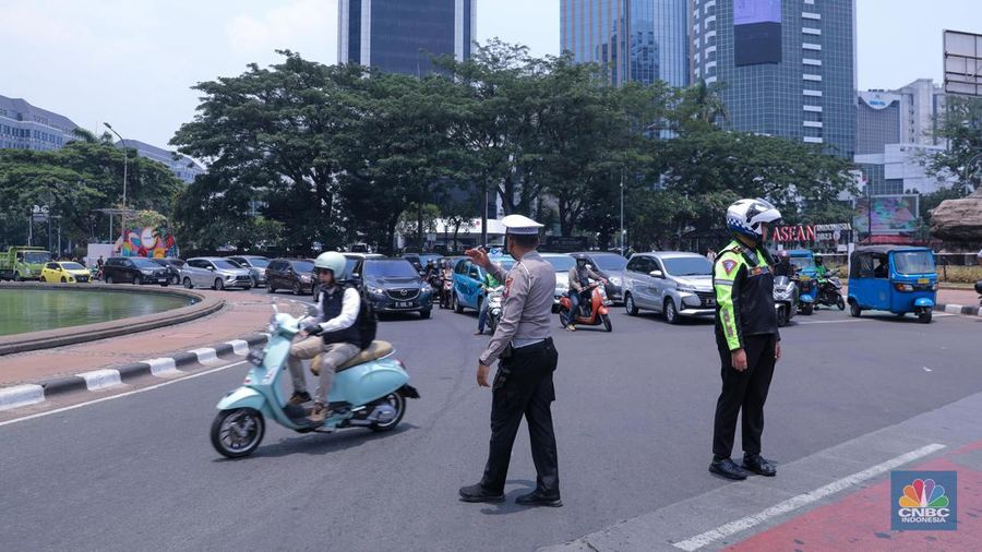 Petugas Kepolisian melakukan pengalihan arus lalu lintas di kawasan Patung Kuda, Jakarta, Senin (16/10/2023). (CNBC Indonesia/Faisal Rahman)