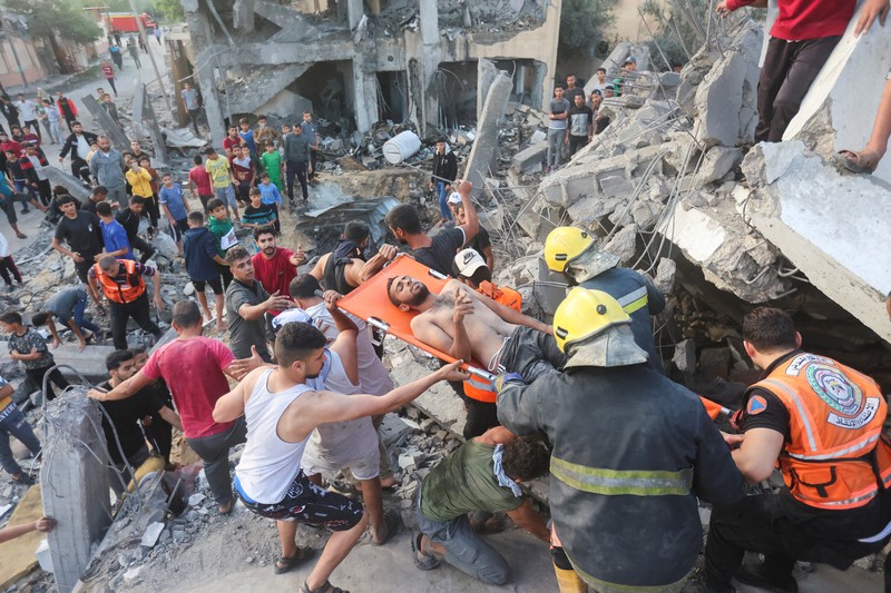 Orang-orang berkumpul saat warga Palestina berupaya mengeluarkan korban dari bawah reruntuhan rumah yang hancur akibat serangan Israel, di Khan Younis di selatan Jalur Gaza 17 Oktober 2023. (REUTERS/Ahmed Zakot) Orang-orang berkumpul saat warga Palestina berupaya mengeluarkan korban dari bawah reruntuhan rumah yang hancur akibat serangan Israel, di Khan Younis di selatan Jalur Gaza 17 Oktober 2023. (REUTERS/Ahmed Zakot)