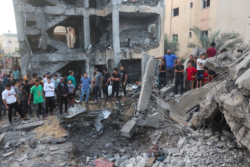 Orang-orang berkumpul saat warga Palestina berupaya mengeluarkan korban dari bawah reruntuhan rumah yang hancur akibat serangan Israel, di Khan Younis di selatan Jalur Gaza 17 Oktober 2023. (REUTERS/Ahmed Zakot) Orang-orang berkumpul saat warga Palestina berupaya mengeluarkan korban dari bawah reruntuhan rumah yang hancur akibat serangan Israel, di Khan Younis di selatan Jalur Gaza 17 Oktober 2023. (REUTERS/Ahmed Zakot)