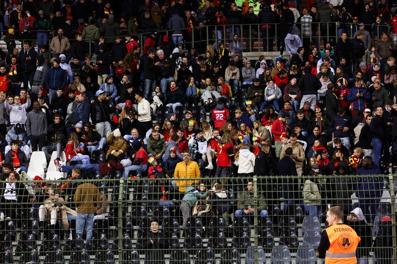 Penonton tertahan di dalam stadion saat laga Belgia vs Swedia pada Kualifikasi Euro 2024 terjadi penembakan di luar stadion. (REUTERS/Yves Herman)