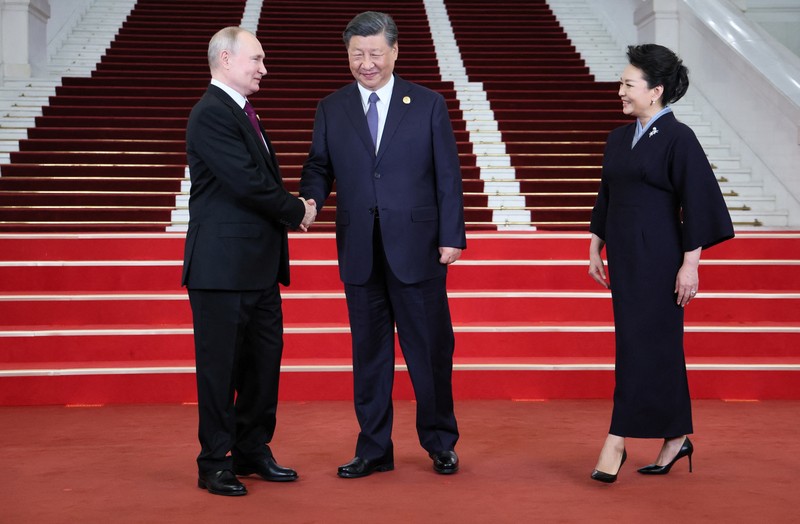 Presiden Rusia Vladimir Putin disambut oleh Presiden Tiongkok Xi Jinping dan istrinya Peng Liyuan dalam upacara di Belt and Road Forum di Beijing, Tiongkok, 17 Oktober 2023. (Sputnik/Sergei Savostyanov/Pool via REUTERS)